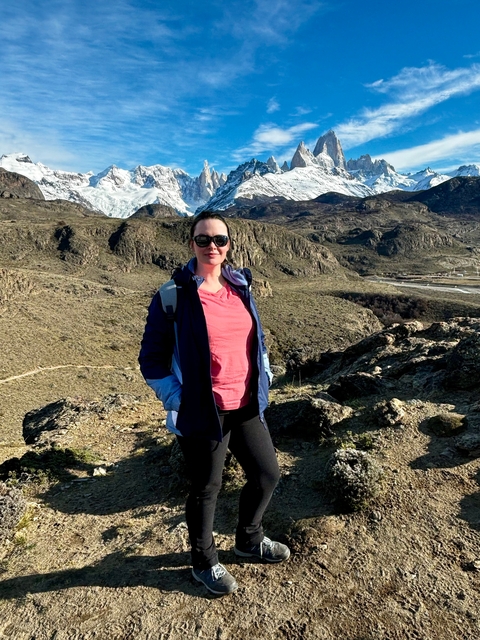 Person standing outdoors with rocky landscape.
