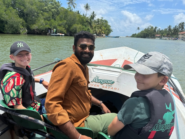 People on a boat ride through a scenic river with trees.