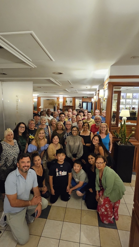       Large group of people posing indoors with smiles.
  