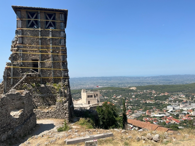 Ruins of a fort with a view of a town below.
