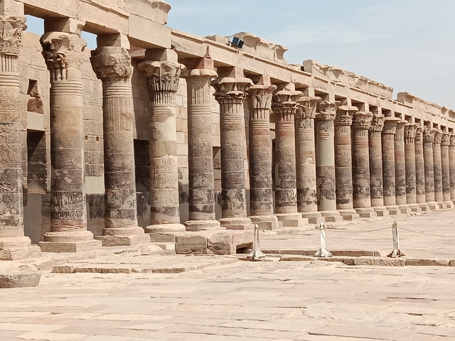 Row of ancient stone pillars with inscriptions on them.