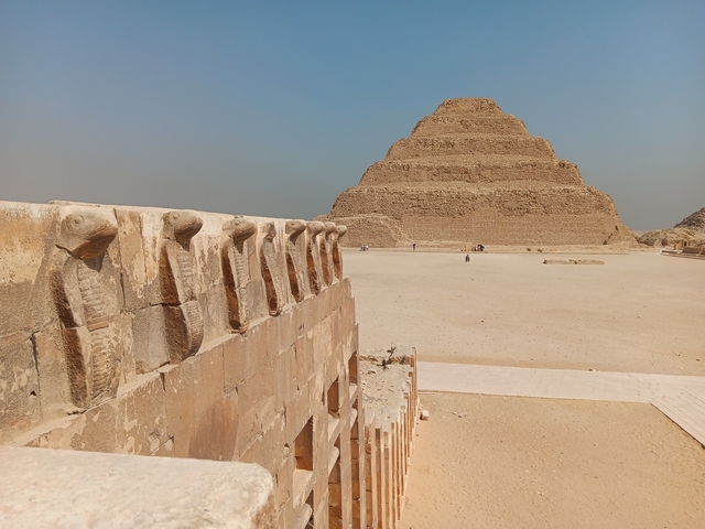 The Step Pyramid in a desert area with detailed stone carvings.