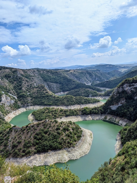 Green valleys and winding rivers under a blue sky.