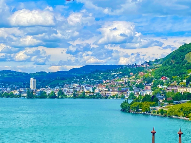 Scenic view of a lakeside city against a mountainous backdrop.