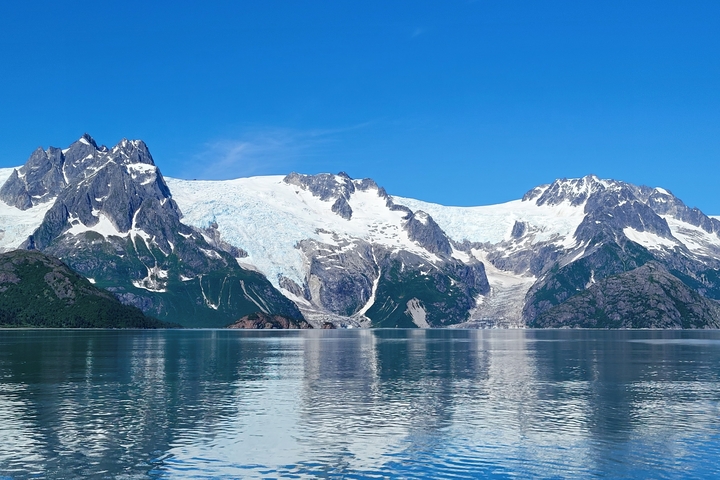 Vast glacier and mountain range with clear skies.