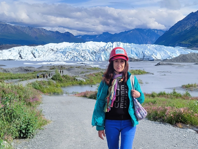       Portrait of a person in front of a glacier in a mountainous area.
  