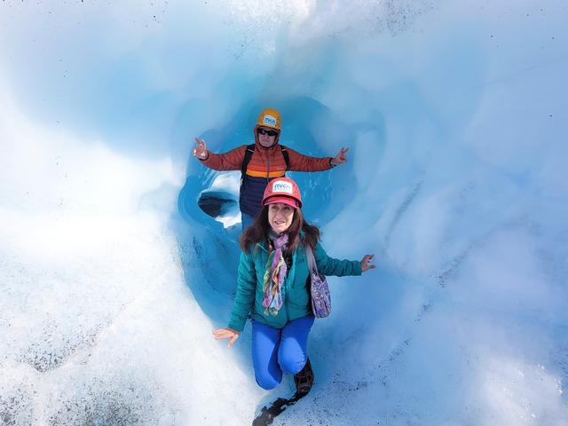       Couple posing inside an ice cave.
  
