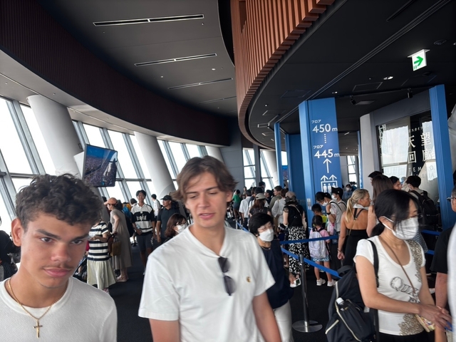       Crowded indoor area of a tall building with large windows.
  