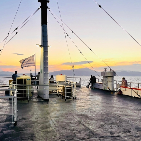       People on a ferry at sunset
  