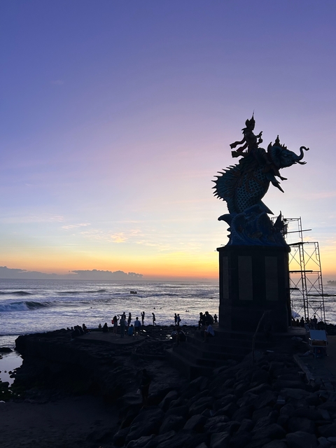 Sunset by a seashore statue