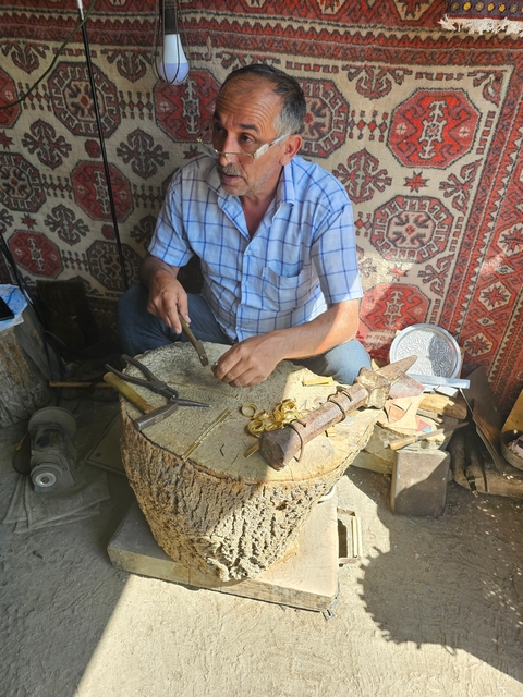 Craftsman working with metal tools and materials.