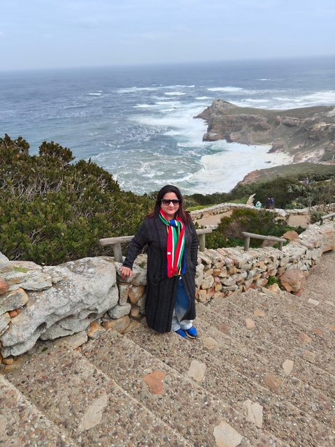 Person standing in front of a scenic coastline