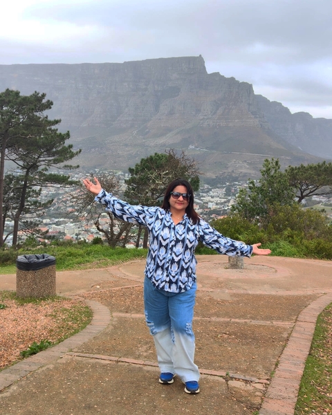 Person posing with city view and mountains