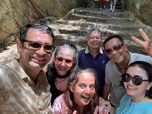 A group of people posing together outdoors, smiling brightly.