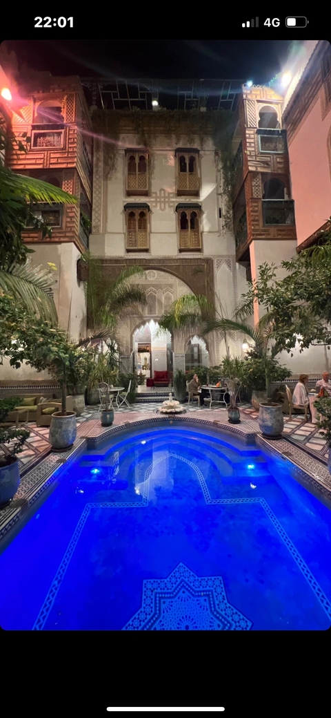       A luxurious indoor pool area with ornate decor and greenery.
  