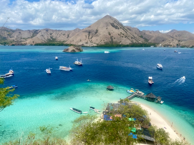       Aerial view of a tropical bay with turquoise water and boats
  