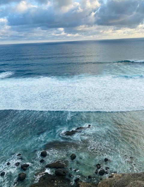       Waves crashing on rocks along a coastal view
  