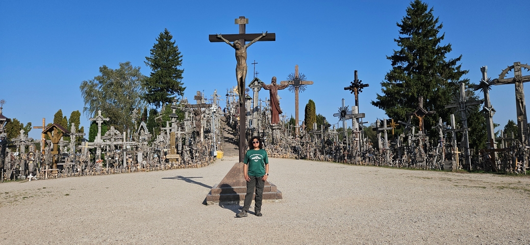       Person standing in front of the Hill of Crosses.
  