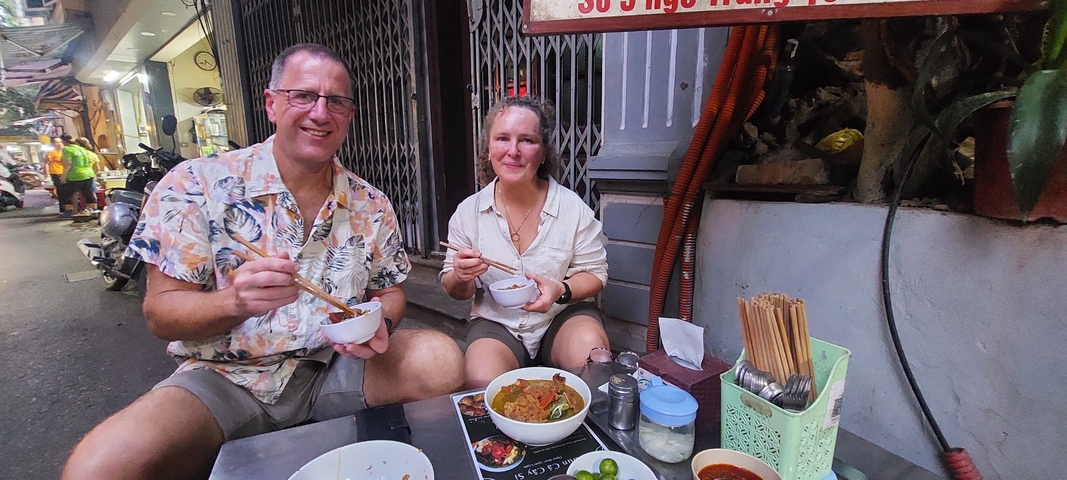 Couple enjoying street food sitting at a small table.