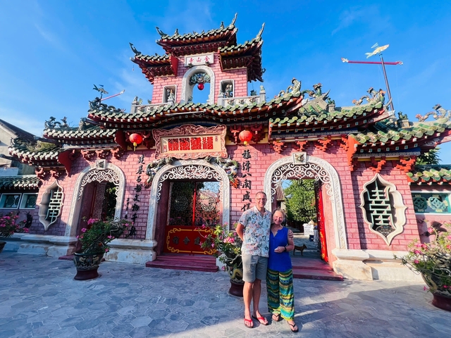       Couple standing in front of an ornate temple entrance.
  