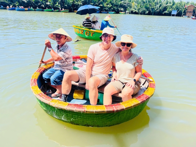Couple sitting in a traditional round boat with a local rowing.