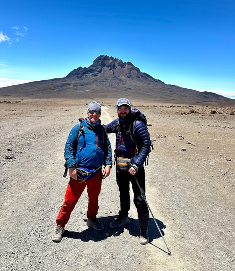 Two hikers posing with a distant mountain view.