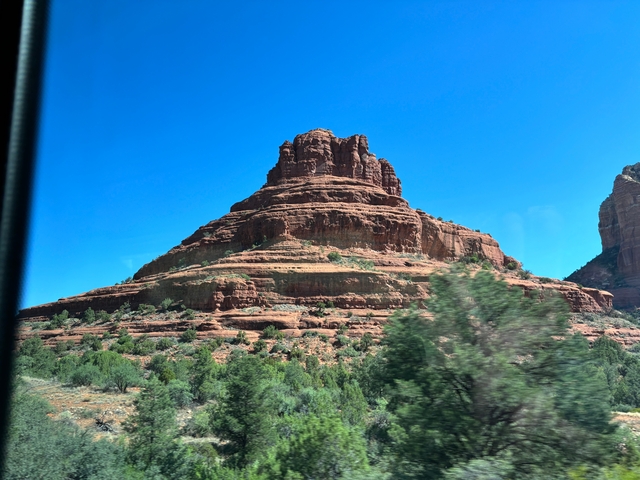 A red rock butte against a clear blue sky.