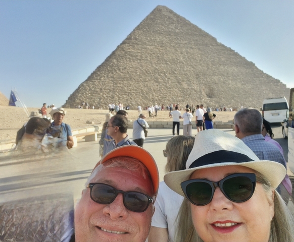People visiting a large pyramid structure.