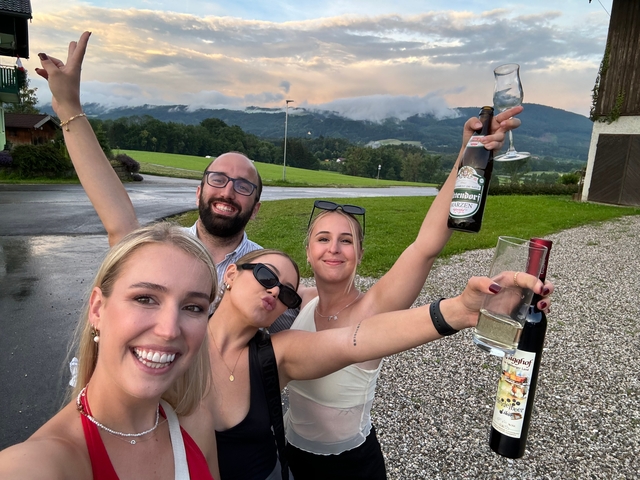 Friends celebrating outdoors with drinks.