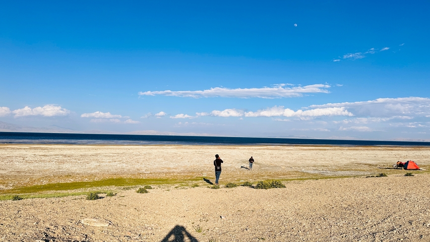 People walking along a dry lake bed.