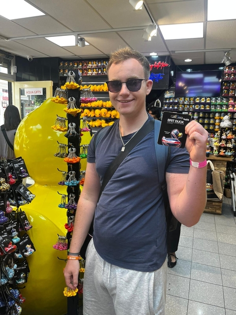 Person holding a 'Brit Duck' souvenir in a shop.