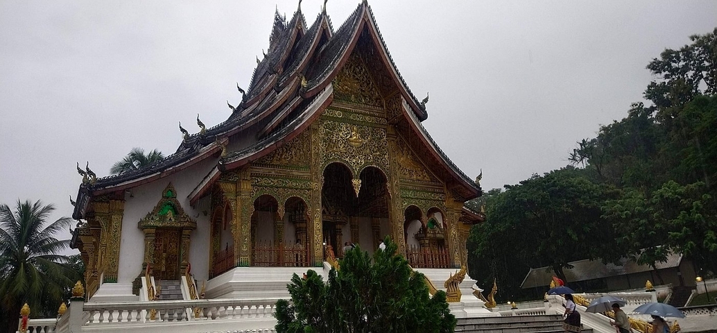       Ornate temple with intricate designs and visitors nearby.
  