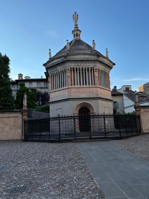       Octagonal building with ornate columns and fenced exterior.
  