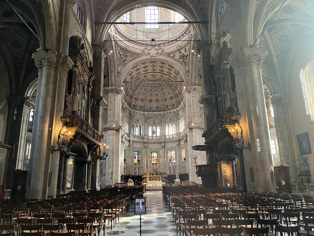 Large cathedral interior with ornate ceiling and stained glass windows.