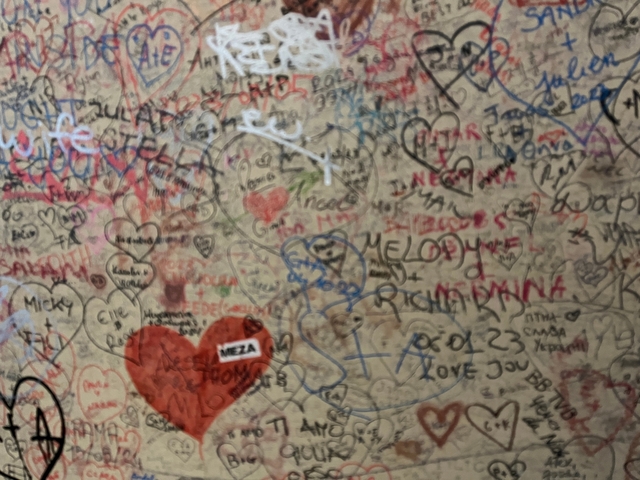       Wall covered with numerous graffiti and love notes.
  