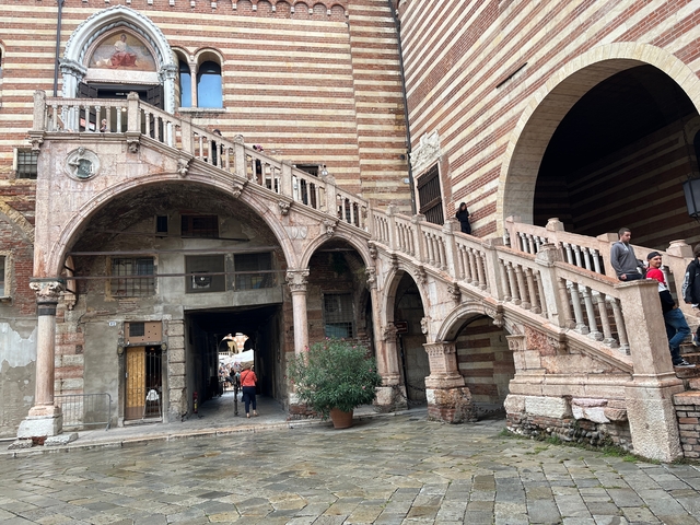 Historic staircase with arches in a city setting.
