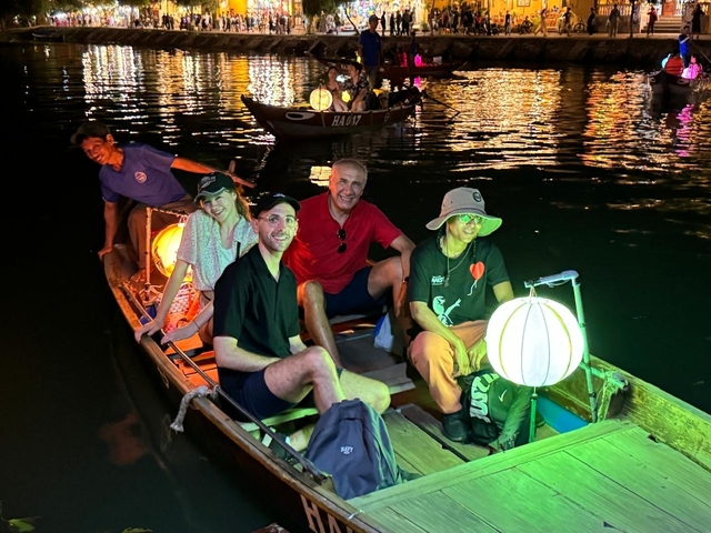 A group enjoying a night boat ride with lanterns.
