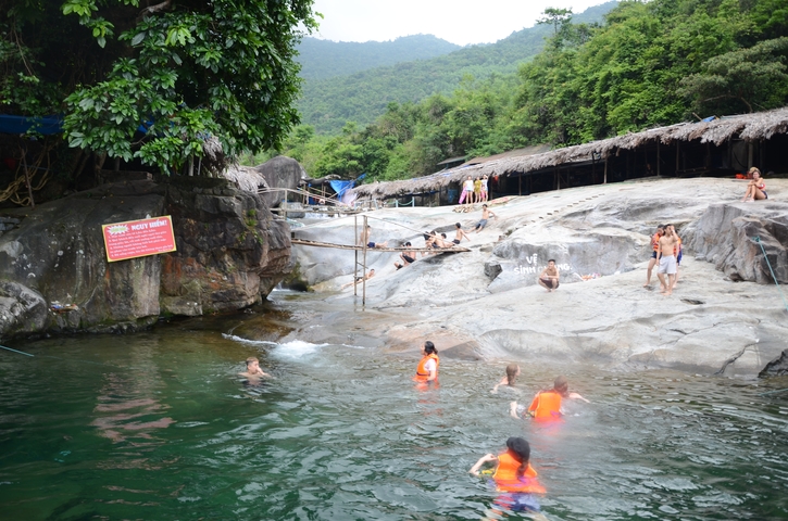 People swimming in a natural rock pool area.