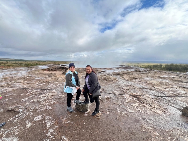       Two women standing near a geothermal area in Iceland.
  