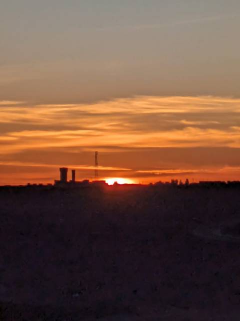       A sunset over a silhouetted cityscape.
  