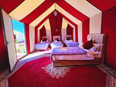       Interior view of a luxurious tent with multiple beds.
  