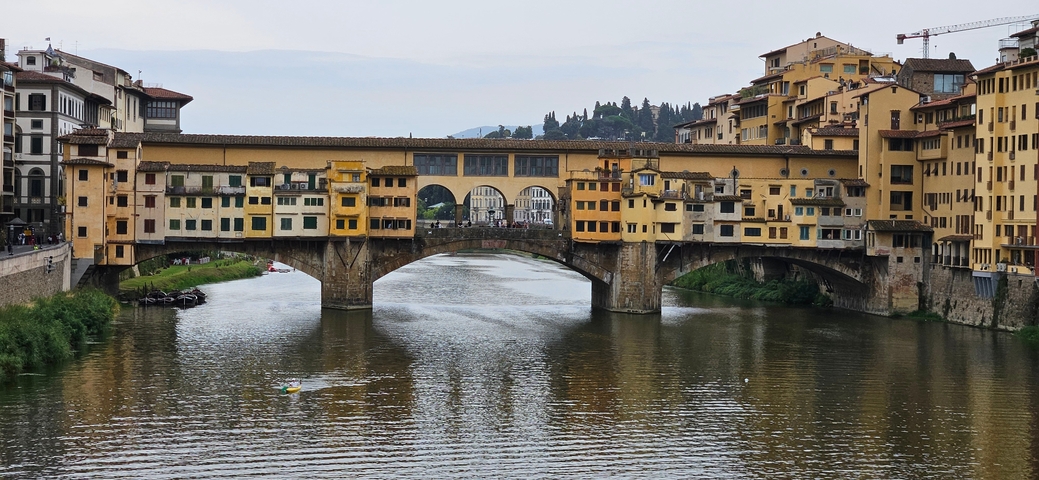       A historic bridge over a river with colorful buildings.
  