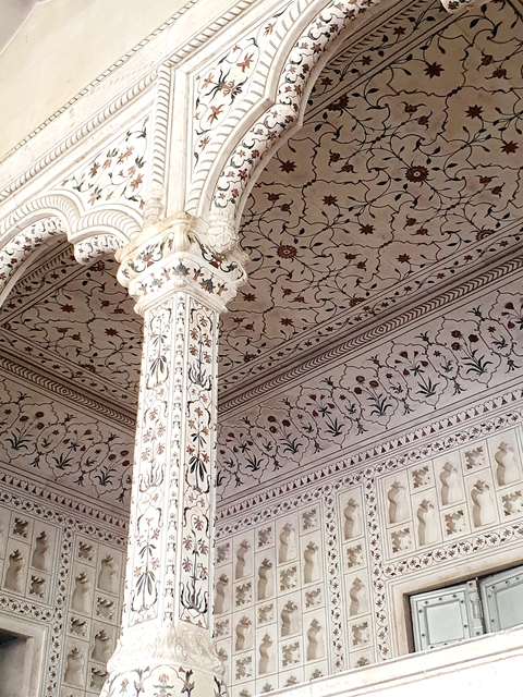       Intricate floral carvings on marble walls and columns.
  