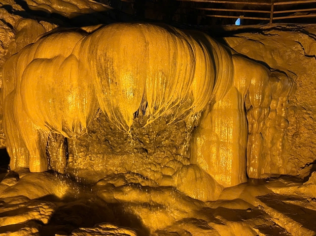 Stalagmites and stalactites in an illuminated cave.