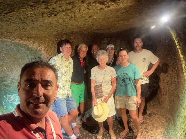 A group of people posing inside an underground structure.