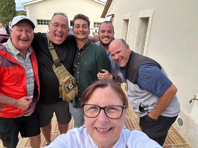       Group selfie with people smiling in an outdoor setting.
  