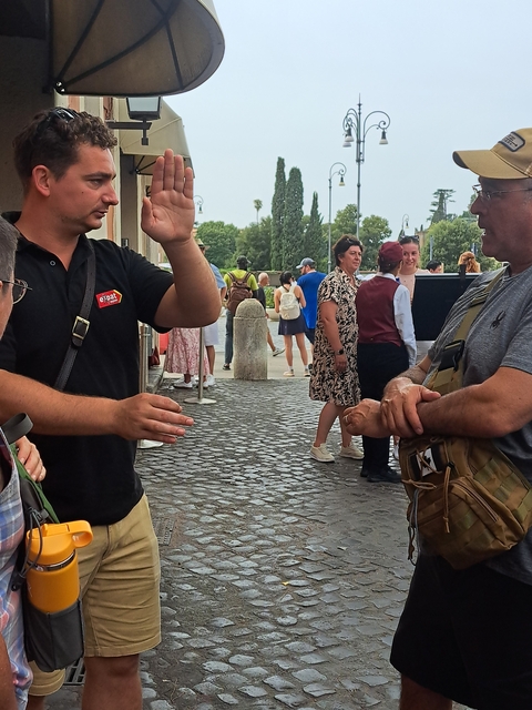      People chatting and gesturing outside a building.
  