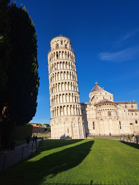 Leaning Tower of Pisa under a clear blue sky.