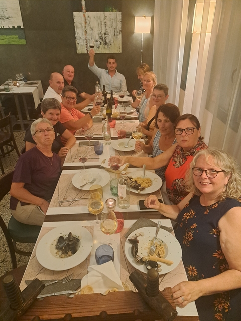       Group of people having dinner, enjoying food and drinks.
  