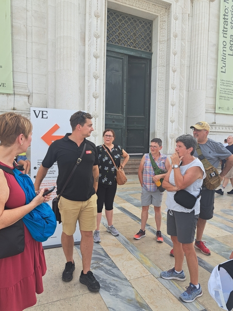 Group of people having a conversation outside a building.